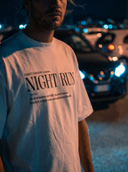 Person wearing a white t-shirt with 'NIGHT RUN' text in a dark, possibly urban setting.